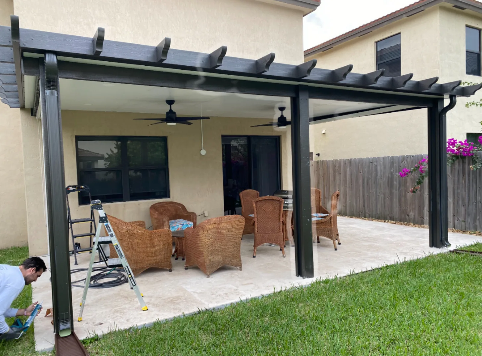 Classic pergola patio cover with decorative rafters, fans, and gutter.