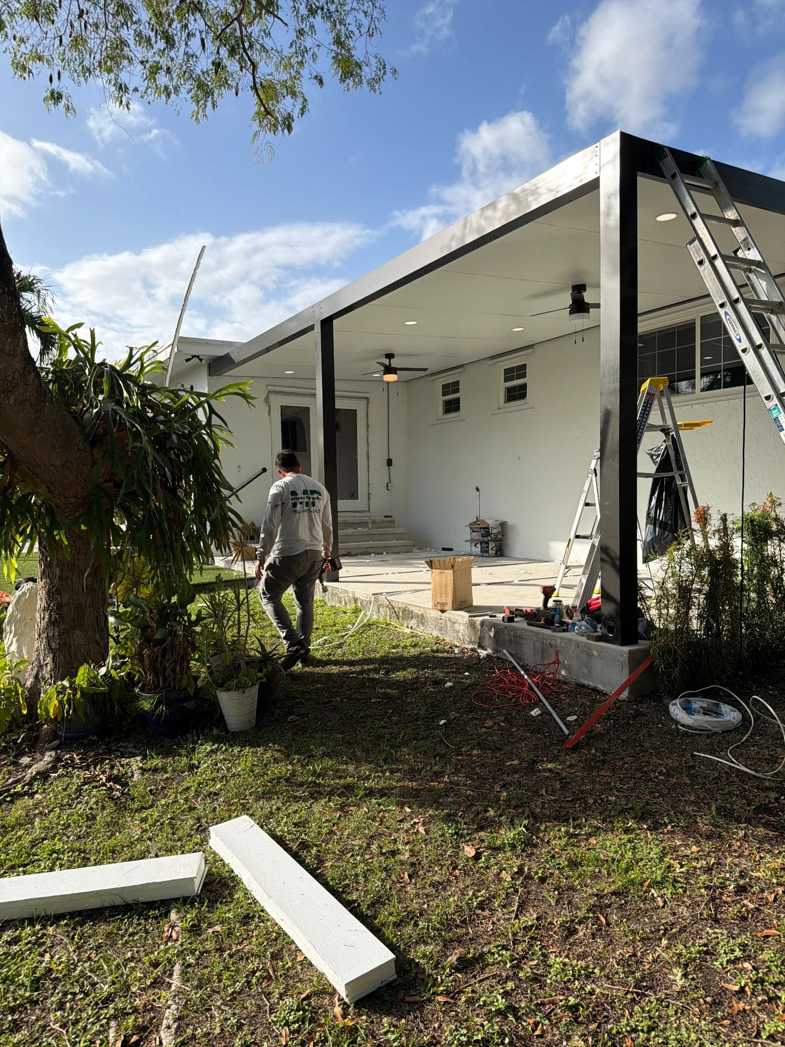 Modern pergola under construction with recessed lights and clean black frame.
