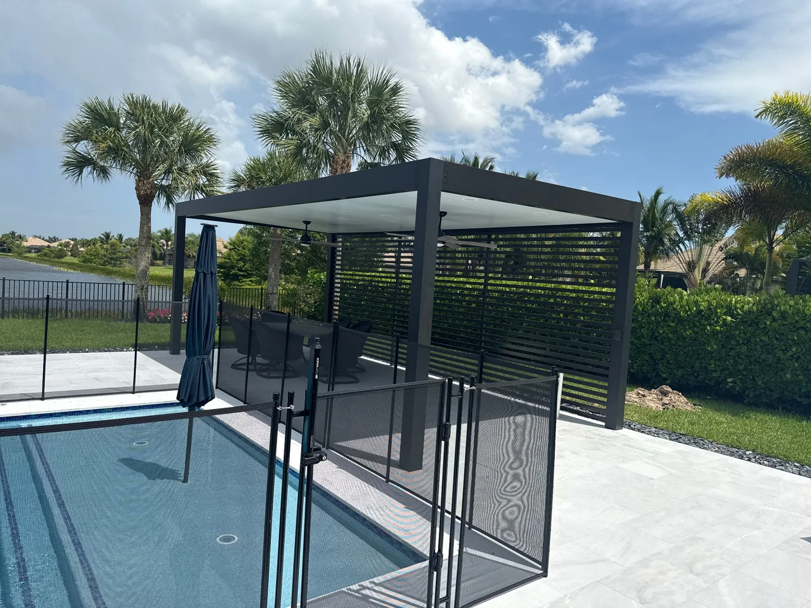 Poolside pergola with horizontal privacy wall and seating area.